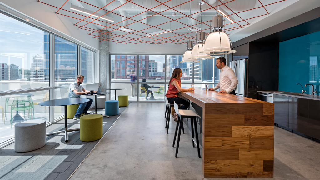 A group of people sitting at a table in a large room.